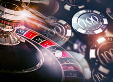 Close-up of a roulette wheel and several casino chips.