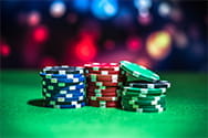 Three piles of casino chips on a green table.