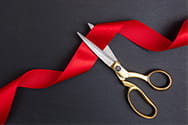 A red ribbon ribbon and scissors.