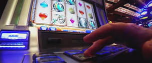 A hand playing a slot machine.
